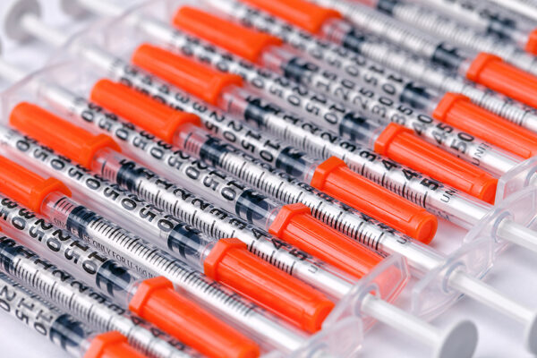 a row of plastic medical syringes